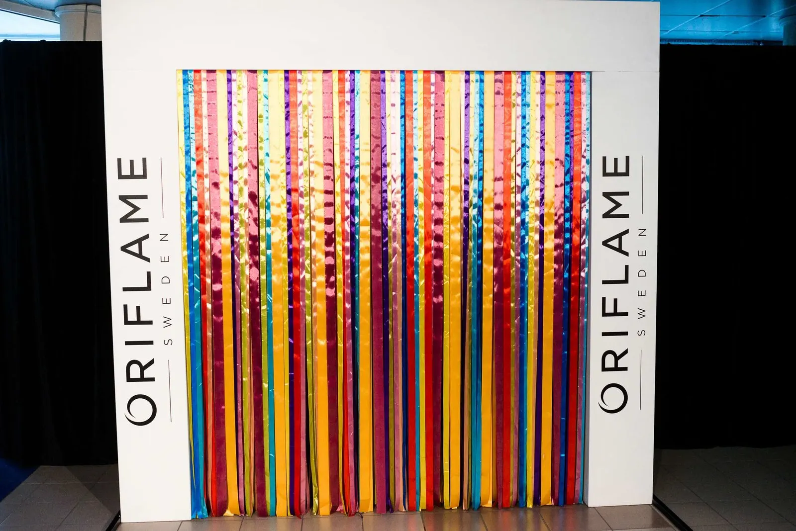 Брендированная фотозона Oriflame с цветными лентами