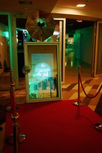 Декоративный элемент в виде картины в раме на красной дорожке как часть оформления ивента.