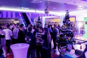 Гости в фойе во время welcome-фуршета на новогоднем корпоративном мероприятии.