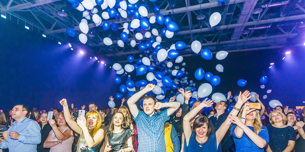 Финал корпоратива ОМА 25 лет — синие и белые шары летят в зал, гости с поднятыми руками