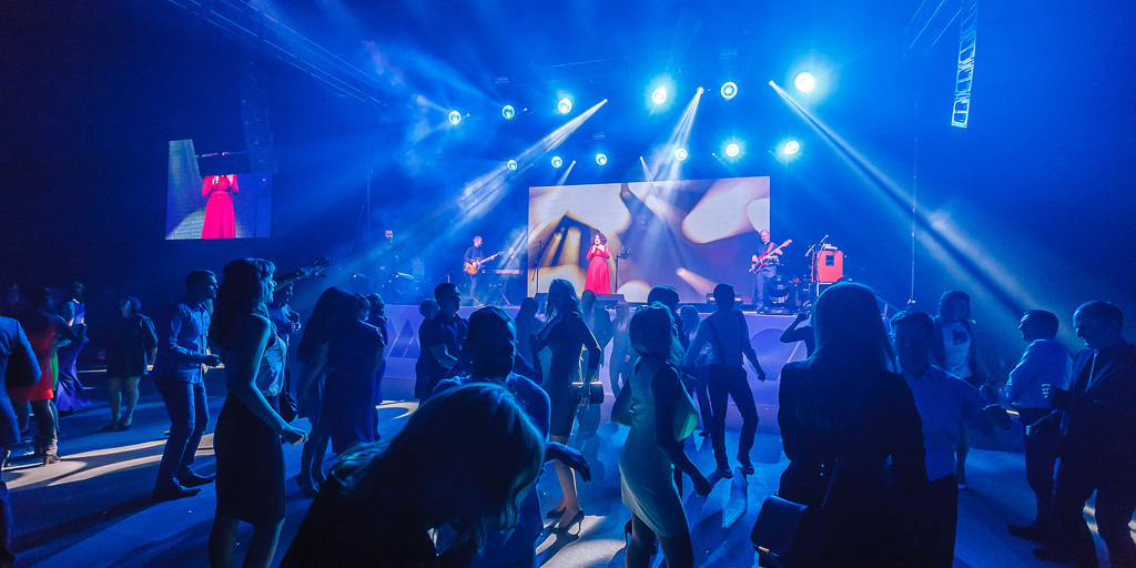 Танцевальная программа на юбилее ОМА 25 лет — сотрудники в синем освещении перед сценой