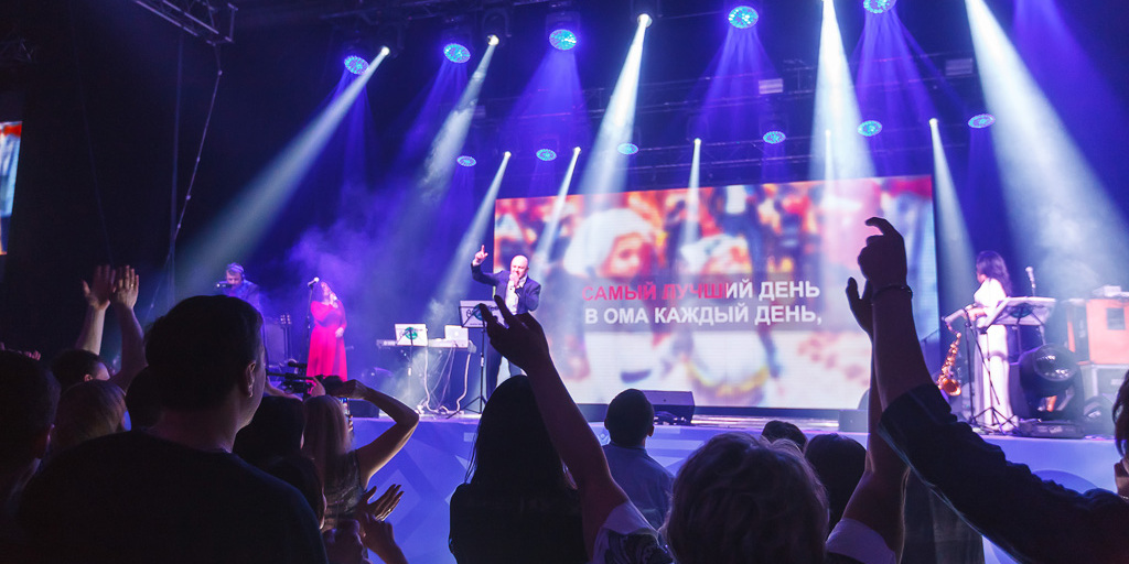 Финальное корпоративное караоке — текст гимна ОМА на экране, весь зал поёт вместе