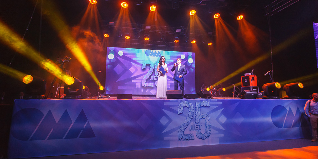 Ведущие на сцене юбилейного вечера ОМА 25 лет в Минске — светодиодные экраны с логотипом компании